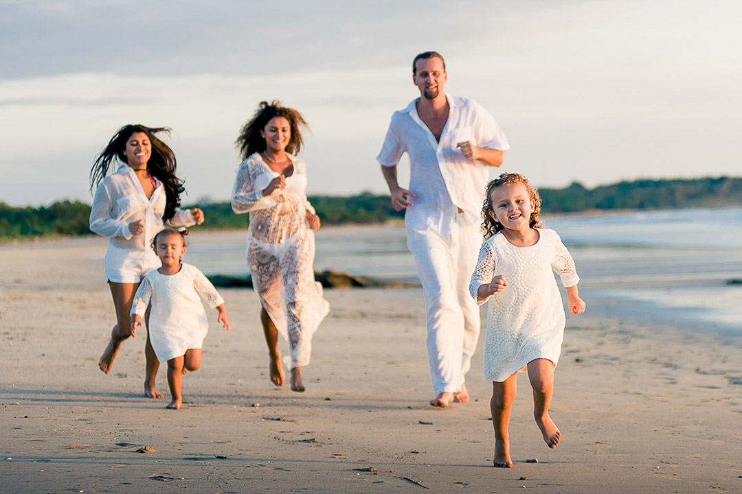 Family beach photoshoot Costa Rica – parents and kids running by the ocean