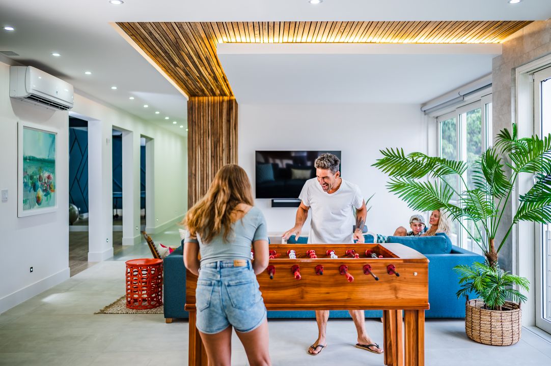 Lifestyle photography Tamarindo – couple playing foosball in modern villa hallway