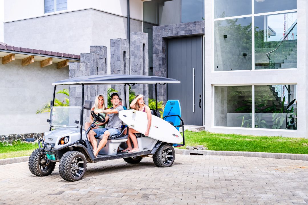 Family lifestyle photography Costa Rica – friends riding golf cart near beach house