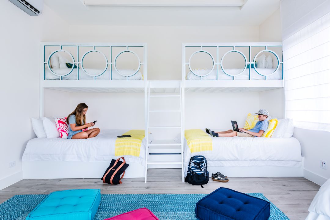 Vacation home photography Costa Rica – girl reading in airy bedroom with vibrant decor