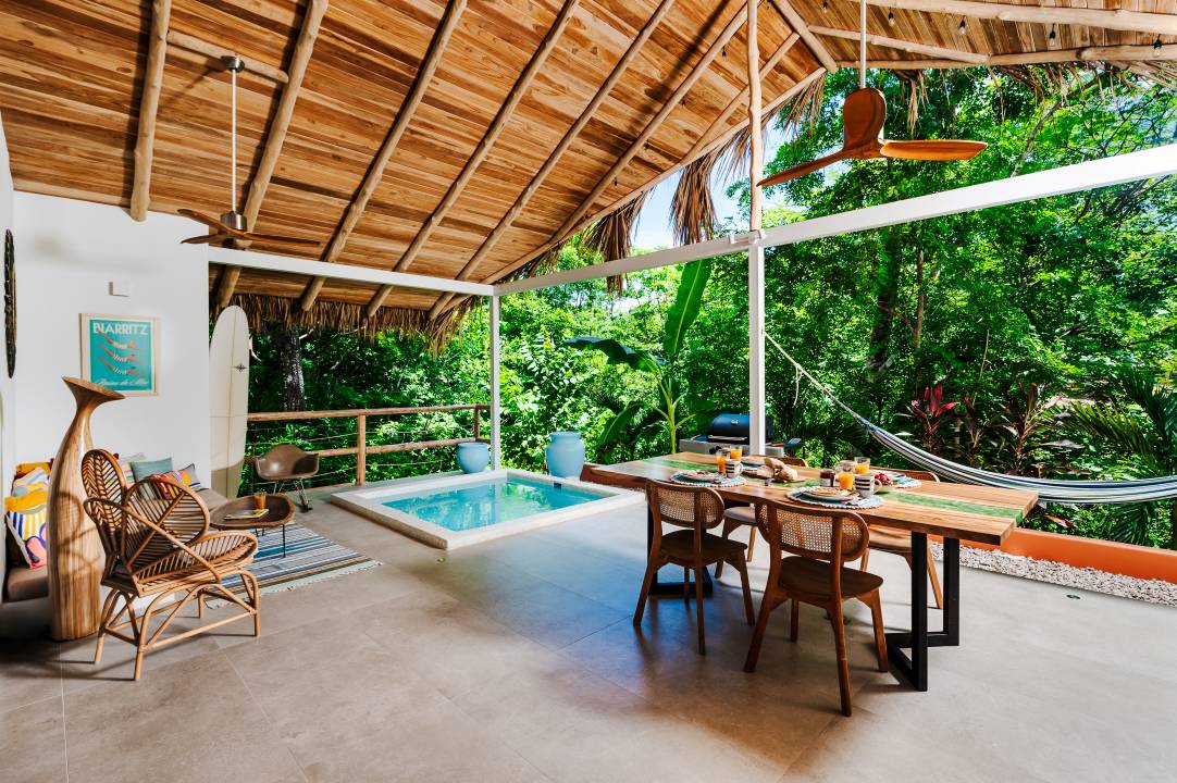 Luxury vacation rental photography – tropical open-air terrace with dining area and pool view