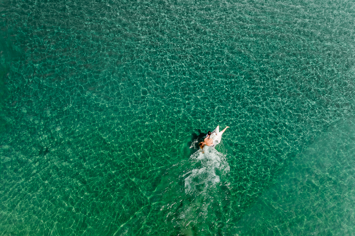 A couple walking in the water in Tamarindo bay