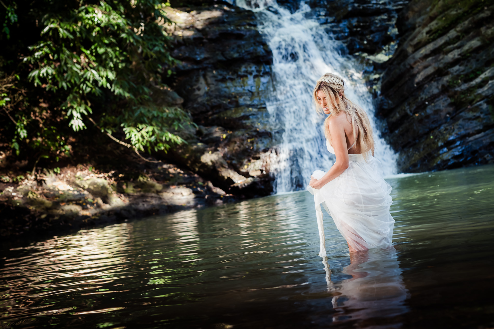 A bride in a pond of water at the Arenal waterfall